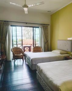 Nabalu Kundasang في Kampong Kundassan: غرفة فندقية بسريرين ونافذة