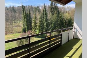 uma varanda com vista para uma floresta de árvores em Spacious Roof Top Maisonett Apartment in PRIEN at Lake Chiemsee em Stock