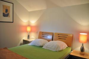 a bedroom with a bed with two pillows and two lamps at Belvedere in Durbuy