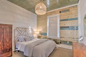 a bedroom with a bed with a wooden wall at Bright Galveston Cottage Close to Beach and Strand in Galveston
