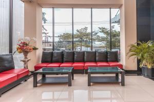 a waiting room with a red couch and tables at Super OYO Collection O 26 Hotel Igloo in Bekasi