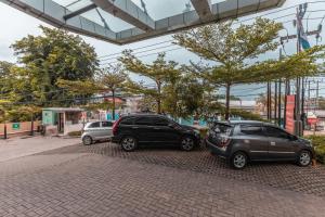 a group of three cars parked in a parking lot at SUPER OYO Collection O Hotel Igloo in Bekasi
