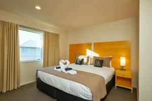a hotel room with a bed with a stuffed animal on it at Kaikoura Luxury Apartments - Formerly Waves Luxury Apartments in Kaikoura