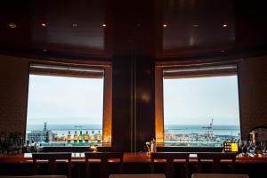 two windows in a bar with a view of the ocean at Authent Hotel Otaru in Otaru