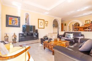 a living room with couches and a tv at Fuengirola Villa Majestic in Mijas