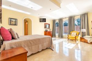 a large bedroom with a bed and a chair at Fuengirola Villa Majestic in Mijas +29 photos