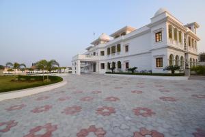 un gran edificio blanco con un patio delante de él en Umaid Farm Resort- A Legancy Vintage Stay In Jaipur en Jaipur