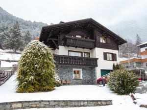 una casa con nieve en el suelo delante de ella en Casa Martinelli - Trameri en Bormio