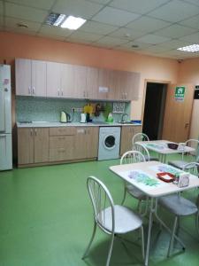 a kitchen with a table and chairs and a refrigerator at Dachny Hostel на метро "Заельцовская" in Novosibirsk