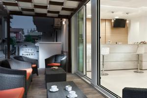a living room with chairs and a table and glass doors at Hotel Rubens in Rimini