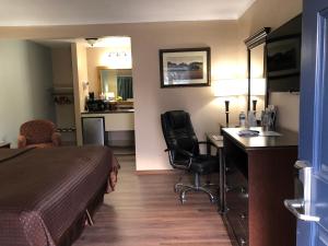 ein Hotelzimmer mit einem Bett und einem Schreibtisch in der Unterkunft Value Inn Motel EUGENE AIRPORT in Eugene