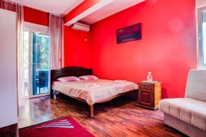 a red bedroom with a bed and a couch at 500 Meters from Grate Beach, App 10 in Ulcinj