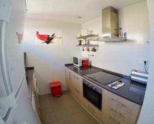 a kitchen with a red bird on the wall at Cerro Mar in El Cerro Blanco