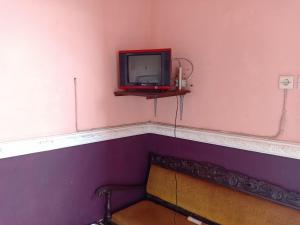 een tv op een plank in een kamer bij OYO 3020 Penginapan Citra Rasa in Sarangan