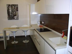 a kitchen with white cabinets and a counter with stools at One bedroom luxury Shota Rustaveli str in Kyiv +8 photos