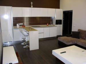 a kitchen and living room with white cabinets and a couch at One bedroom luxury Shota Rustaveli str in Kyiv