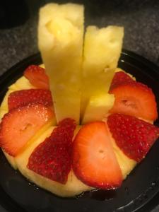 a piece of fruit with pineapple and strawberries on a plate at Donna's Bed & Breakfast in White Rock