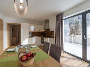 kuchnia i jadalnia ze stołem i misą owoców w obiekcie Appartement Strasser w mieście Söll
