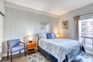 a bedroom with a bed and a chair and a window at Sand & Sea: Coastal Range (312) in Seaside