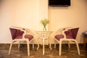 two chairs and a table with a vase on it at Villa Suối Mùa Xuân in Da Lat