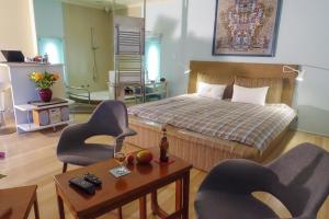 1 dormitorio con 1 cama, 2 sillas y mesa en Rosedene Lodge - 24h solar with pool and garden, en Ciudad del Cabo