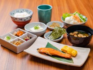 a table with a plate of food and bowls of food at UNIZO INN Osaka Kitahama in Osaka