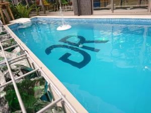 a swimming pool with a dollar sign in the water at Green Rich Hotel Okinawa Nago (Artificial hot spring Futamata Yunohana) in Nago