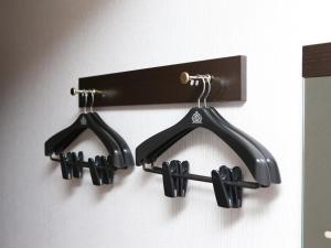 a wall mounted rack with three pairs of shoes at APA Hotel Nambaminami Ebisucho Eki Shinsekai in Osaka