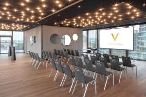 a conference room with chairs and a screen at Hotel Victoria in Basel