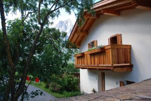 a balcony on the side of a building with trees at Appartment Gsolerhof in Castelrotto