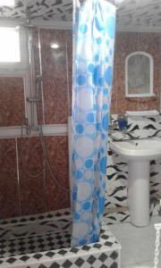 a shower curtain in a bathroom with a sink at Ilgar's Hostel in Sheki