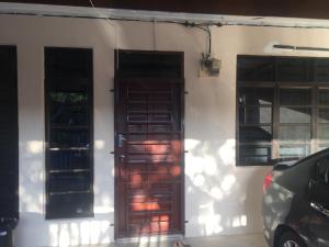 a house with two doors and a car parked outside at WARDAH HOMESTAY in Kampong Gong Badak