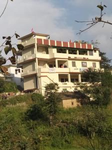 a large white building on top of a hill at Vamoose Sparrow Nest in Rānīkhet