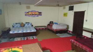 a room with two beds and a red carpet at Vamoose Sparrow Nest in Rānīkhet