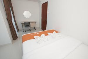 Un dormitorio con una cama con dos arcos blancos. en Apatel Roseville SOHO & Suite, en Tangerang