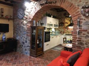 cocina y sala de estar con pared de ladrillo en Casa Ravi, en Gavorrano