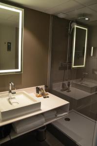 a bathroom with a sink and a shower at Novotel Beaune in Beaune