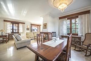 uma sala de estar com uma mesa de madeira e cadeiras em Casa Can Pou em Cala Millor