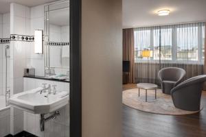 bagno con lavandino e sedia di Hotel Victoria a Basilea