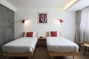 2 Betten in einem Zimmer mit weißen Wänden in der Unterkunft Potala Guest House in Kathmandu