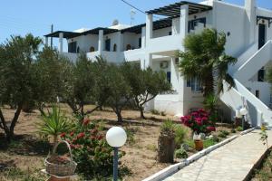 a building with trees and flowers in front of it at STAVROS STUDIOS in Logaras