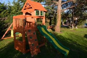 a playground with a slide and a play house at Guest House "Près des Montgolfières" in Angé