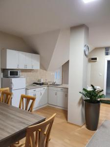 a kitchen with white cabinets and a table and chairs at Bella Apartman in Szeged