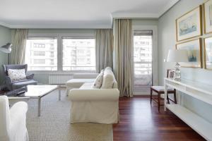 聖塞巴斯提安的住宿－Koxka - Basque Stay，客厅配有2张白色沙发和2把椅子