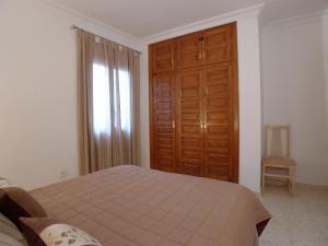 a bedroom with a bed and a wooden door at Torrox Beach Club in Torrox Costa +17 photos