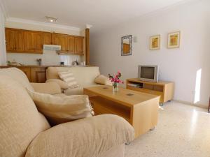 a living room with a couch and a tv at Torrox Beach Club in Torrox Costa
