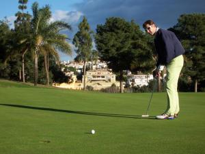 a man playing golf on a golf course at Torrox Beach Club in Torrox Costa