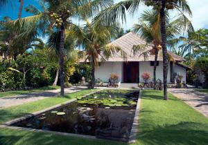 um lago em frente a uma casa com palmeiras em Villa Paradise Lovina em Temukus