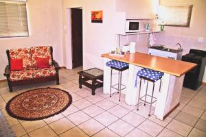 cocina con encimera, mesa y silla en Kaniklani Guest Apartments, en Kakamas