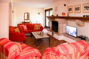 sala de estar con muebles de color rojo y chimenea en Villa Apostolico with private pool, en Éboli